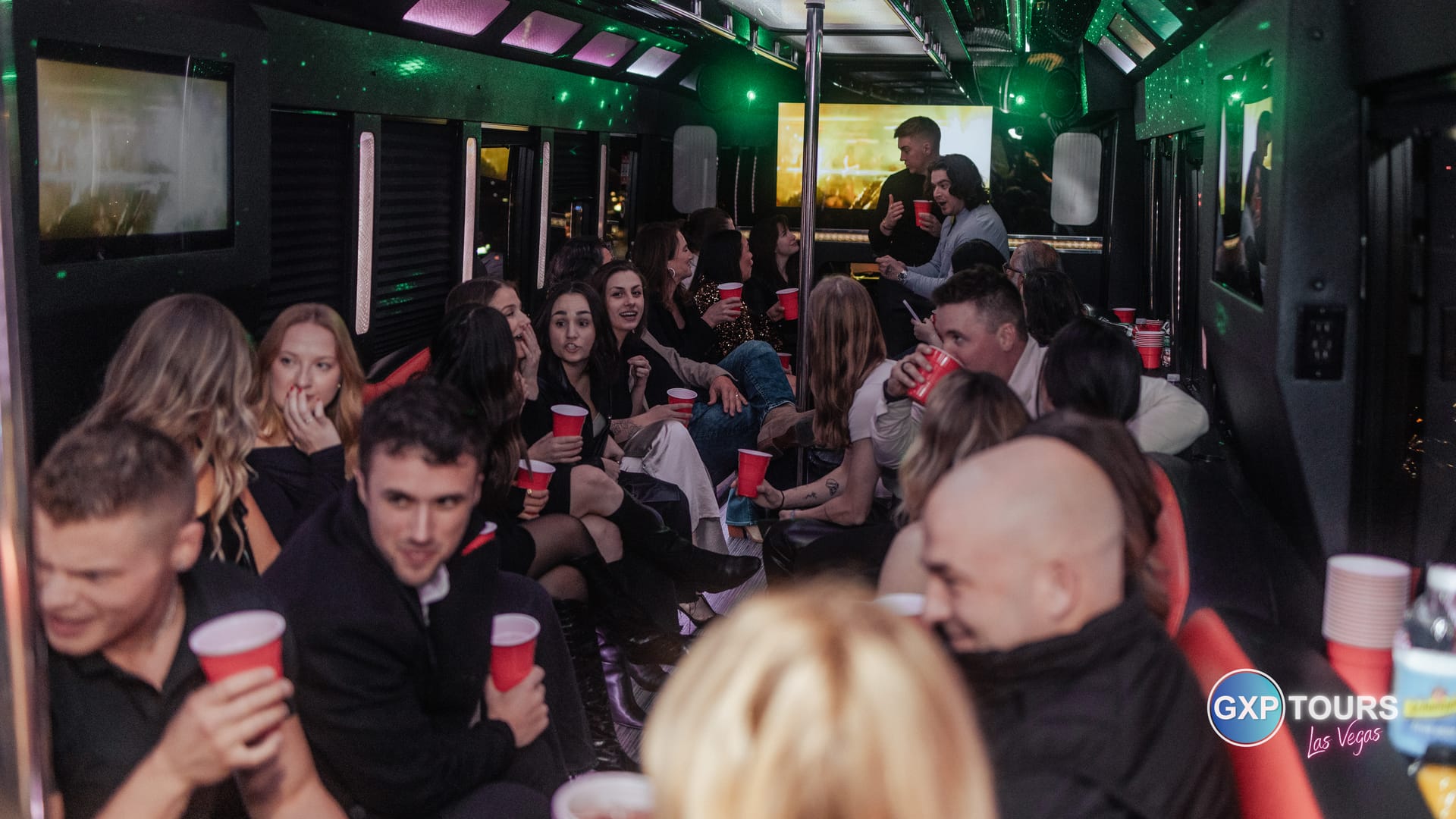 Corporate group riding a private GXP Tours party bus through Las Vegas at night
